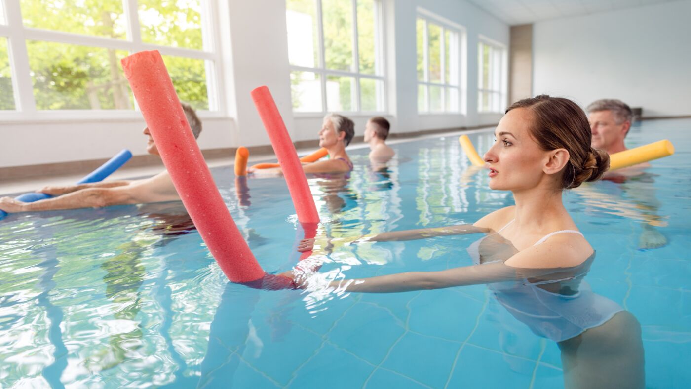 People having fun with noodles in an aqua class