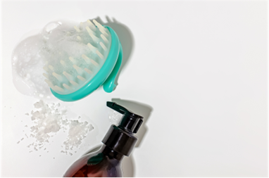 A scalp brush and bottle of hair tonic
