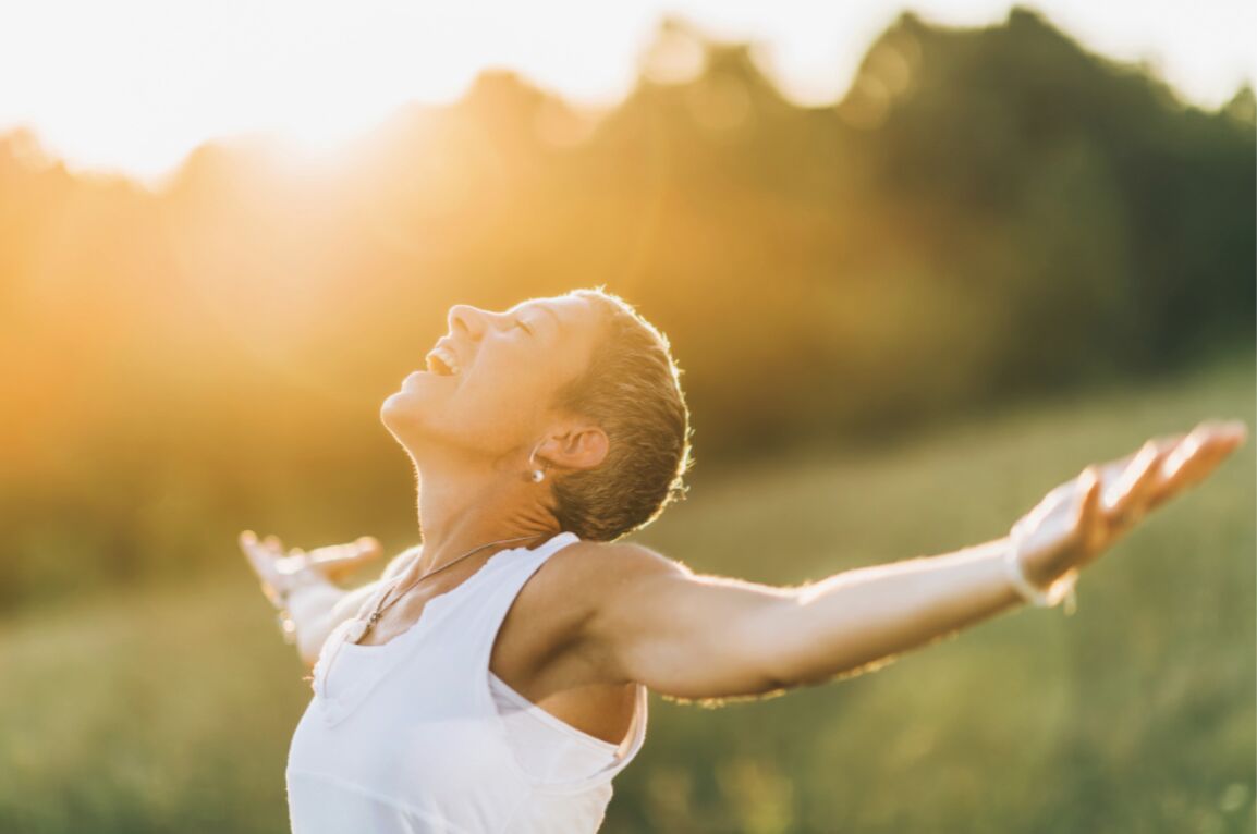 A woman embracing the sunshine while outdoors.