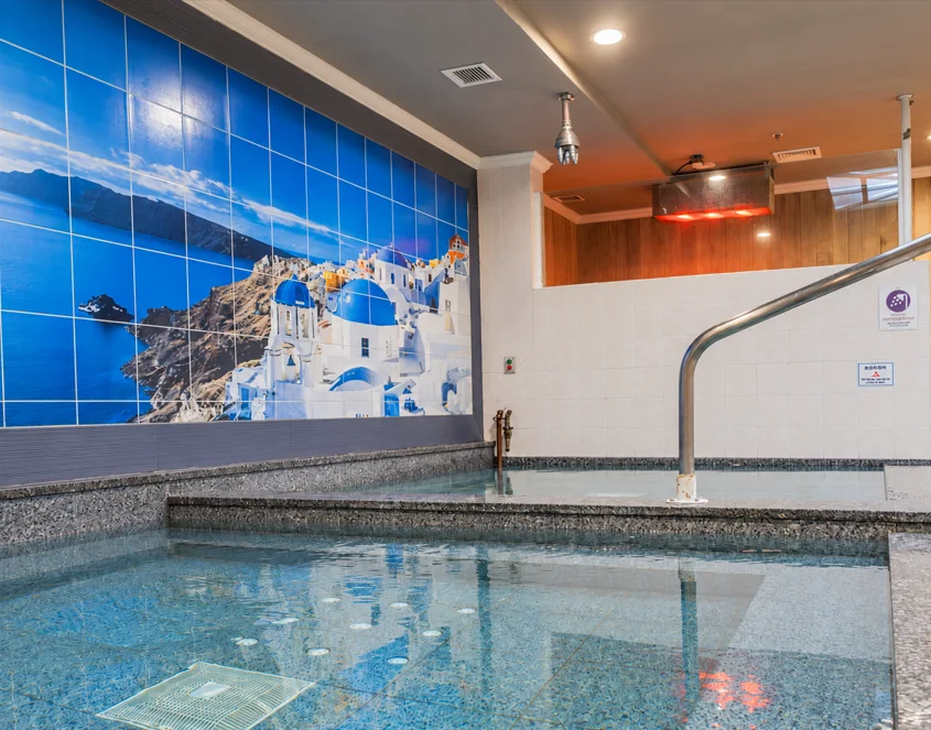 CGI hot and cold plunge tubs beside the Santorini mural