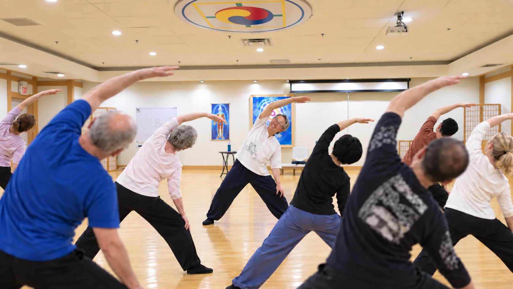 Body & Brain trial class at CGI Holistic: instructor leading a group side stretch