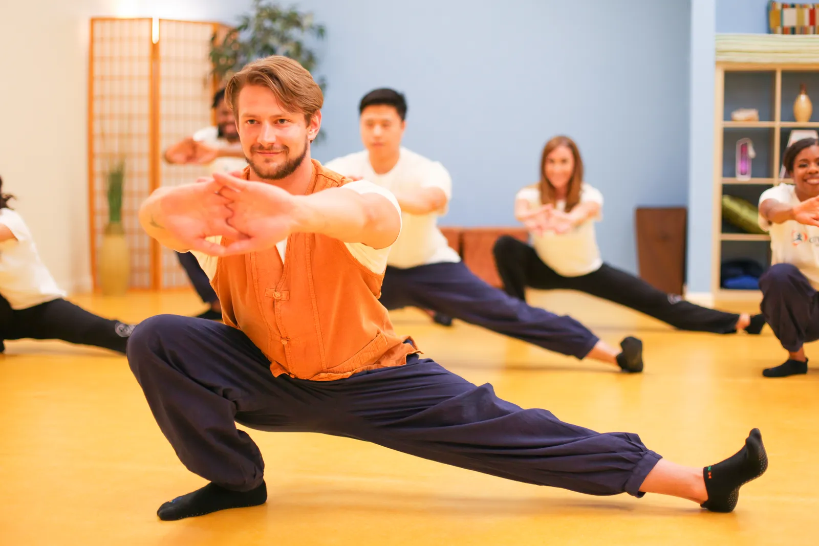 Korean Yoga class at CGI: instructor leading a deep side lunge stretch